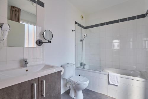 a bathroom with a toilet and a tub and a sink at Résidence Odalys Terra Gaia in Sète