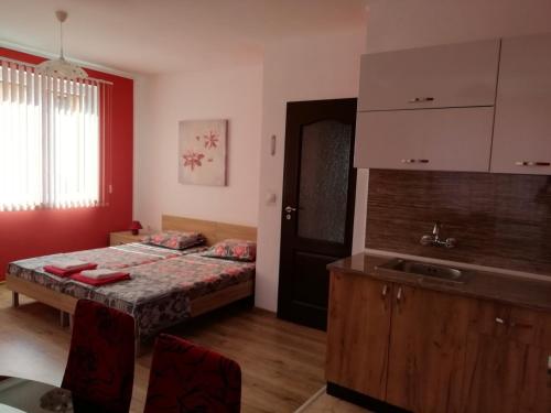 a bedroom with a bed and a sink in it at Guest House Nedelchevi in Primorsko