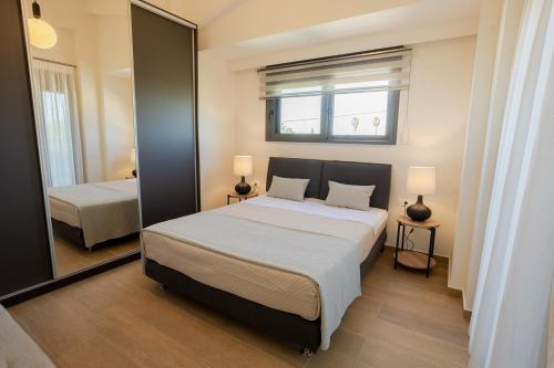 a bedroom with a large bed and a mirror at Forestbreeze in Metóchion