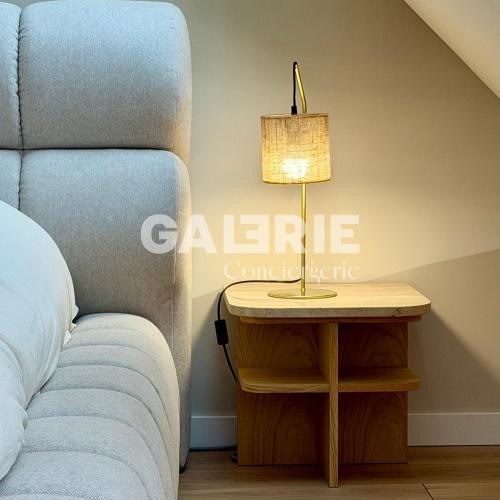 a table with a lamp on it next to a bed at GC - Les Oyats in Wissant