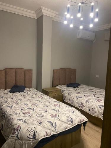 a bedroom with two beds and a chandelier at Bissan Condimenium in Amman