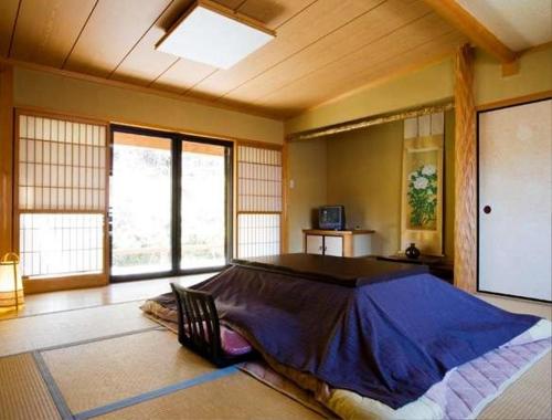 1 dormitorio con 1 cama grande en una habitación con ventanas en Hanaya Tokubei en Tenkawa