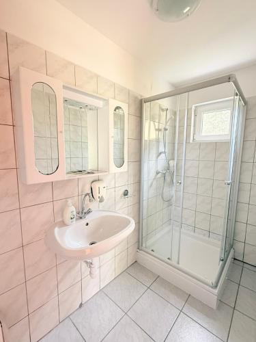 a bathroom with a sink and a shower at Hotel Magnólia in Balatonszepezd