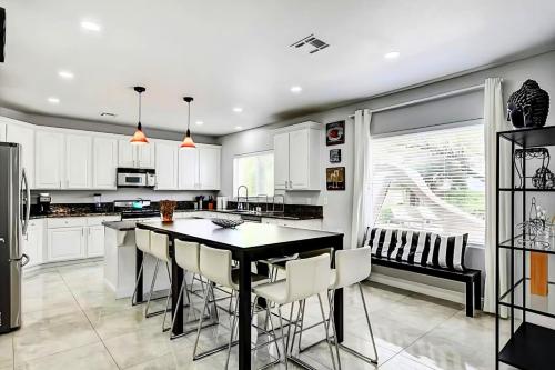 a kitchen with white cabinets and a black table and chairs at Summerlin Private Buddha Estate Resort - Pool, Spa, Sauna, Game Room, Basket ball, Mini golf, Gym in Las Vegas