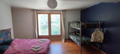 a small bedroom with a bunk bed and a window at Le Mazet in Nohèdes
