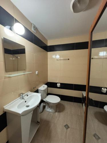 a bathroom with a white sink and a toilet at Yuliya Guest House in Sapareva Banya