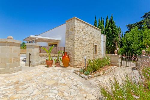 a stone house with a courtyard with plants at Masseria L'Uliveto Agri Resort in Otranto
