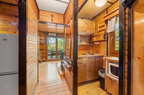 a kitchen with wooden walls and wooden flooring at Chatka Kačka in Jedovnice