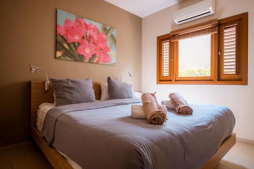 a bedroom with a large bed with two pillows on it at Luxury Ocean View Apartment, Private Beach, Infinity Pool, near Jan Thiel C4 in Willemstad