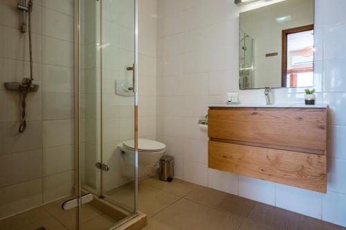a bathroom with a shower and a toilet and a sink at Luxury Ocean View Apartment, Private Beach, Infinity Pool, near Jan Thiel C4 in Willemstad