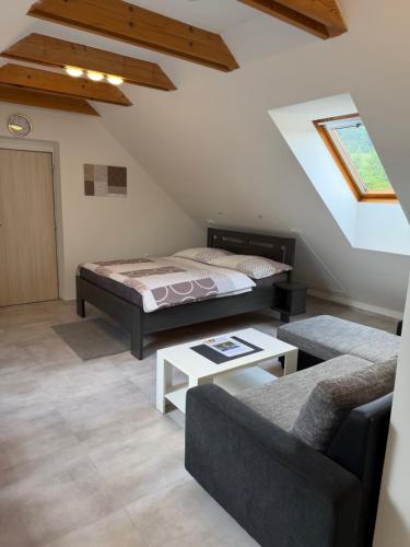 a living room with a bed and a couch at Apartmány Polevsko in Polevsko