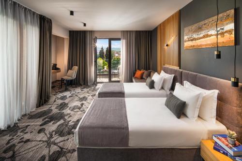 a hotel room with two beds and a desk at Kamengrad Hotel & SPA in Panagyurishte