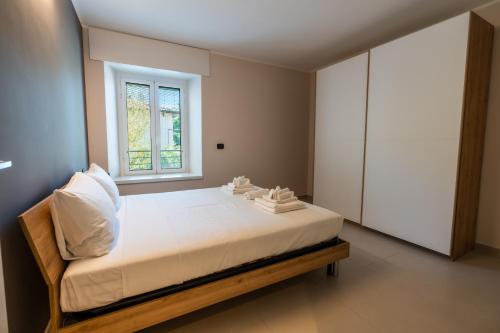 ein Schlafzimmer mit einem weißen Bett und einem Fenster in der Unterkunft Casa Luccon in Salionze