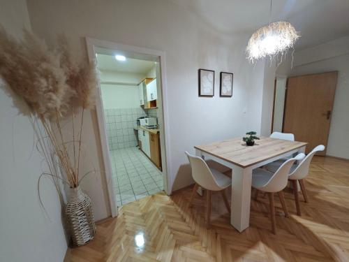 a dining room with a table and chairs and a vase at Queen's Apartment Ohrid in Ohrid