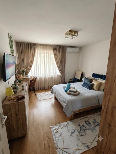 a bedroom with a large bed and a television at Teslić Apartman NiA in Teslić
