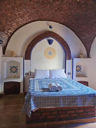 a bedroom with a bed with a brick wall at Healing House in Luxor