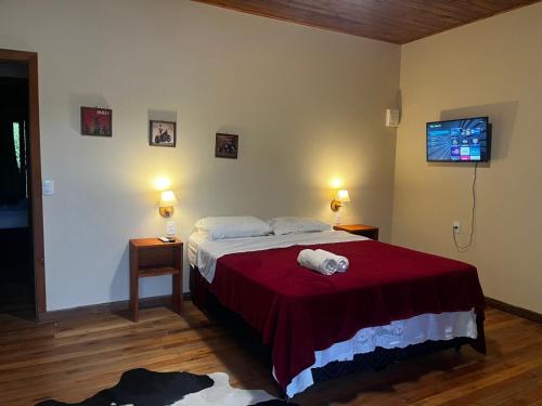 a bedroom with a bed with a red blanket at Hotel Pirâmides Sagradas in Grão Pará