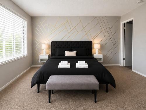 a bedroom with a large black bed and a chair at Maple n Main Hoover Modern 2BR Escape 2E in Hoover