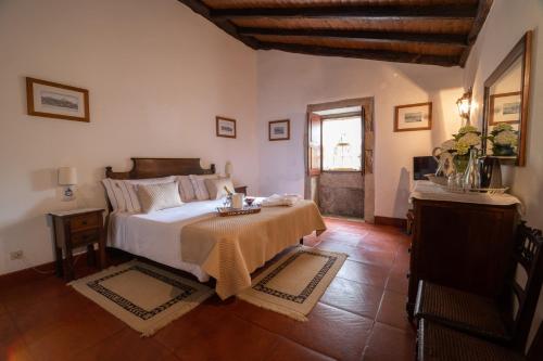 a bedroom with a bed and a table in it at Casa De Anquiao - Turismo de Habitação in Ponte de Lima