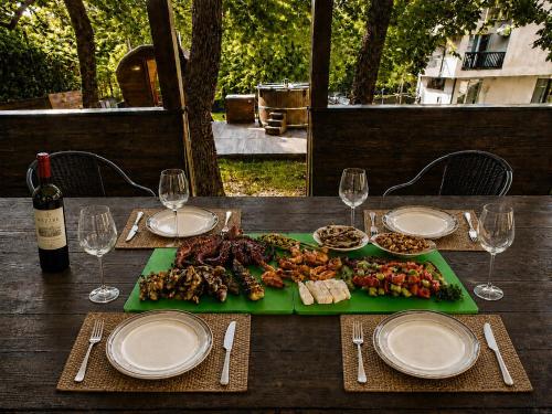 a table with a plate of food and glasses of wine at Villa Eloris in Pismenovo