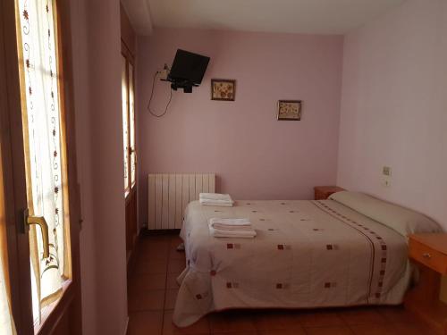 a bedroom with a bed and a tv on the wall at Casa rural Casa Camilo in Agüero