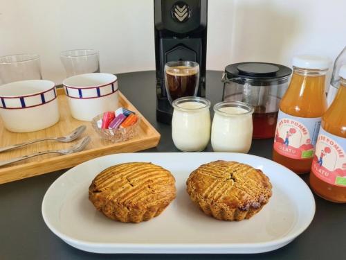 two cookies on a plate on a table with milk at La Noisette Basque - Nuits au verger in Saint-Pée-sur-Nivelle
