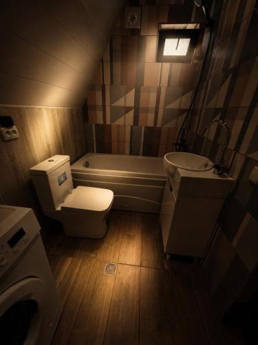 a bathroom with a toilet and a sink and a tub at Asureti Horizon Cottage in Asuretʼi