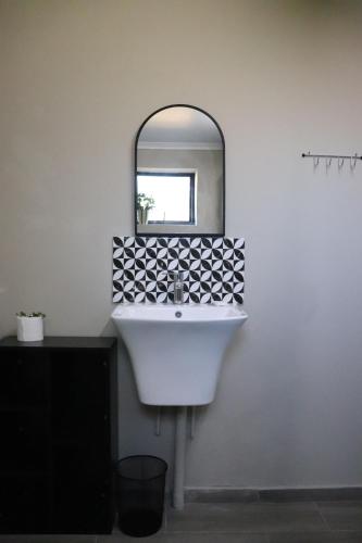 a bathroom with a white sink and a mirror at Favour House in Bethlehem