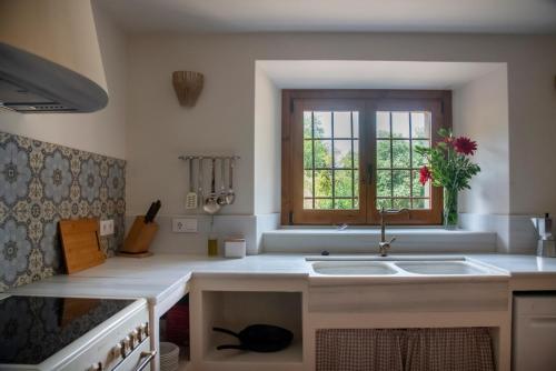 a kitchen with a sink and a window at Can Quel in Canet de Adri