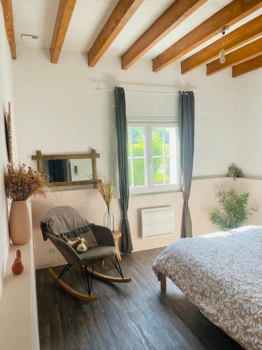 a bedroom with a bed and a chair and a mirror at La morvandelle in Limanton