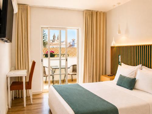 a hotel room with a bed and a balcony at Hotel Sol Algarve by Kavia in Faro