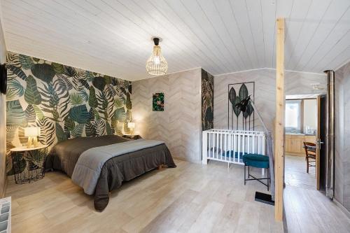 a bedroom with a bed and a crib in it at Gîte Du Tonnelier - 7min Puy du Fou in Sevremont