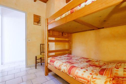 a bedroom with two bunk beds and a chair at Le Chêne - La Fontinelle in Bessas