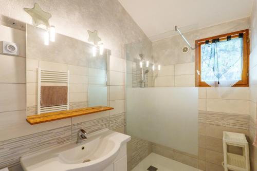 a white bathroom with a sink and a mirror at Le Chêne - La Fontinelle in Bessas