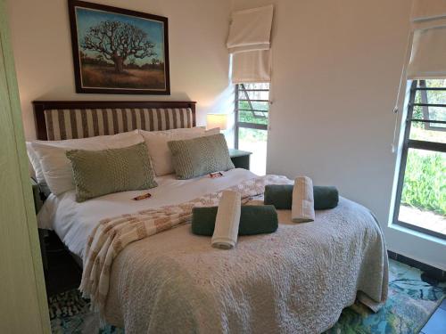 a bedroom with a bed with two pillows on it at A Little Guesthouse in Bloemfontein