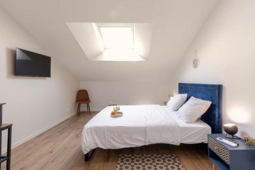 a bedroom with a white bed with a blue headboard at Suite Attrape-Rêves - jardin - 2p in Sainte-Geneviève-des-Bois