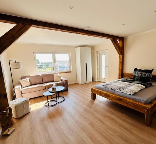 a large room with a bed and a couch at Ferienwohnungen Soldanski in Loddin