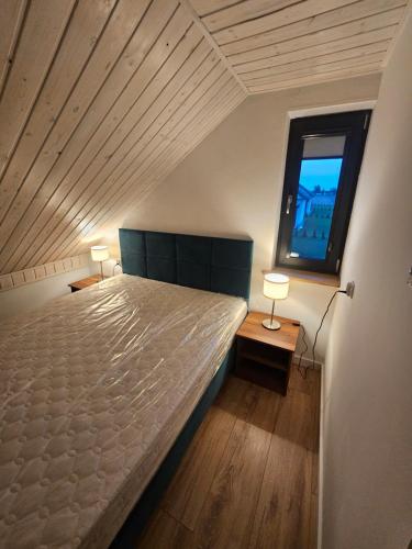 a bedroom with a large bed and a window at Letnisko nad jeziorem in Skulsk