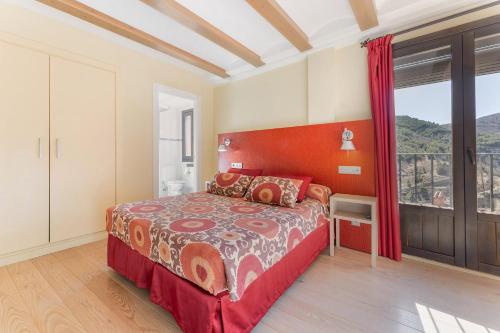 a bedroom with a large bed and a large window at OTTIUM Albanuracín in Albarracín