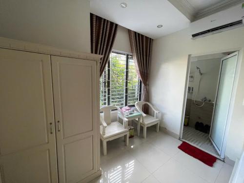 a bathroom with a mirror and a table and chairs at Anh Duong in Lục Yên