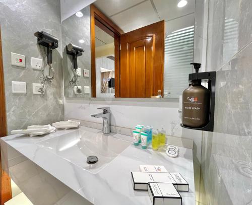 a bathroom with a sink and a large mirror at Zowar Alalami Hotel - فندق زوار العالمي in Medina