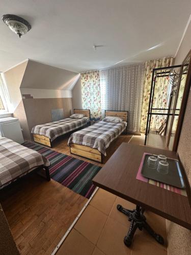 a hotel room with two beds and a table at ЭКО готель ,,Челентано ,, in Slavuta