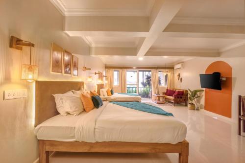 a bedroom with two beds and a living room at Raposo Resorts in Vagator