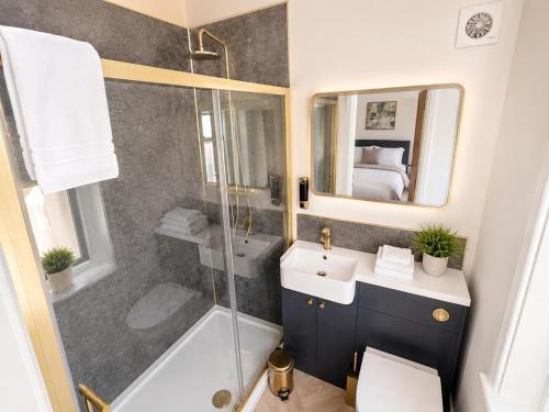 a bathroom with a shower and a sink and a mirror at Castle Chambers Serviced Apartments in Lancaster