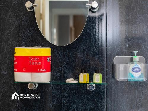 a bathroom with a mirror and a container of toilet tissue at Comfy 2-Bedroom Family & Contractor Home in Bolton with Free Wi-Fi and Street Parking By North West Accommodation in Bolton