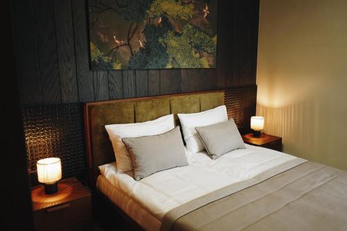 a bedroom with a large bed with two lamps at Камінь in Ostrovets
