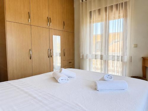 a bedroom with a white bed with towels on it at Cretan Nature Stone Apartment in Ayiás Filakaí