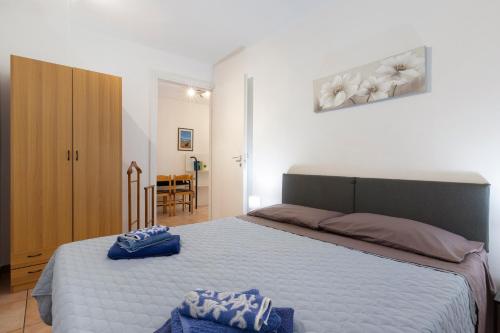 a bedroom with a bed with two blue towels on it at Lola House tra Alghero e Stintino in Palmadula