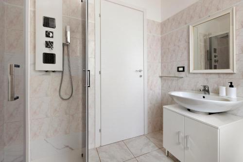 a white bathroom with a sink and a shower at Lola House tra Alghero e Stintino in Palmadula