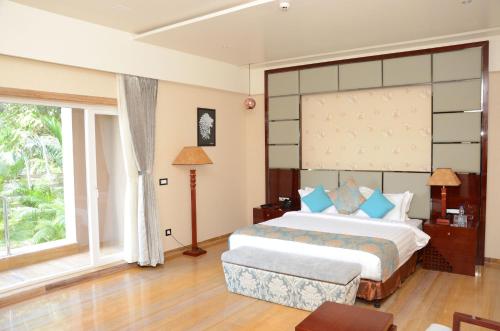 a bedroom with a large bed and a large window at 7 Seasons resort & Spa in Jamnagar
